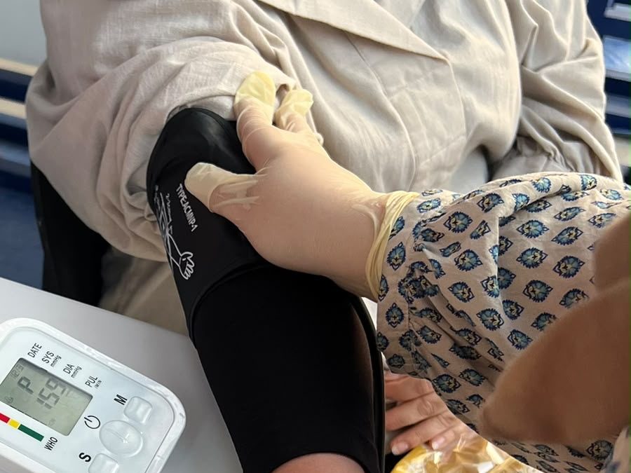 Volunteer measuring blood pressure at a first aid point